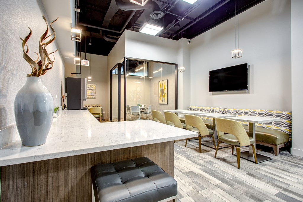 a lobby with a counter and chairs and a vase