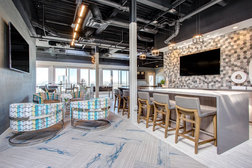 a lobby with chairs and a bar and a television