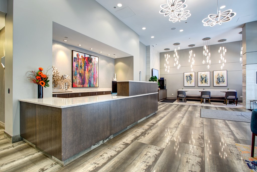 the lobby of a hotel with a reception desk and chairs