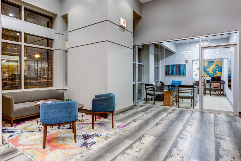 a living room with a couch and chairs in front of a glass door