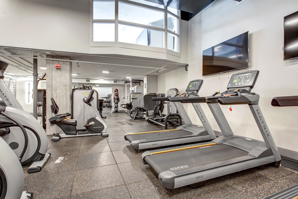 a gym with treadmills and other cardio equipment in a building