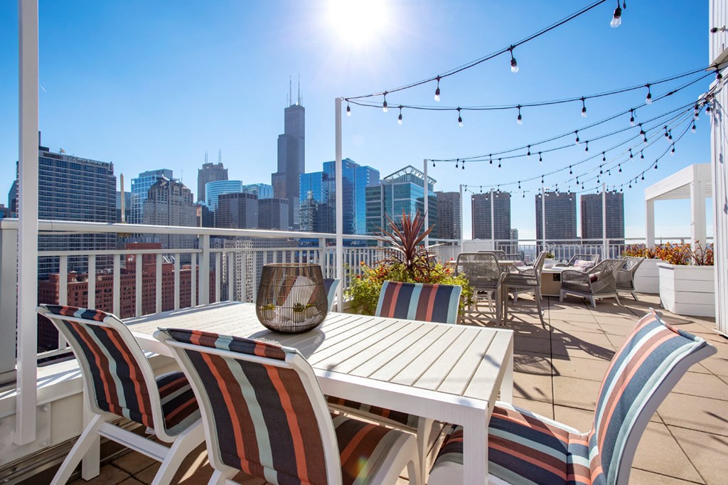 a deck with a table and chairs and a view of the city
