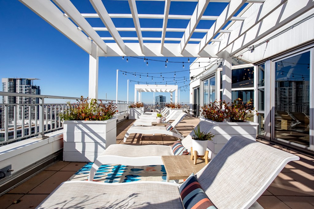 a roof deck with tables and chairs and a view of the city