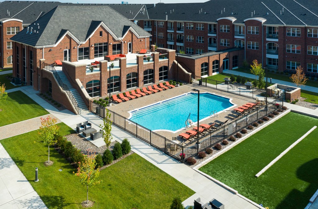 Luxury apartments with brick exteriors, outdoor entertainment lounge with grilling stations, luxury swimming pool, poolside lounges, and manicured gardens at Luxembourg Apartments