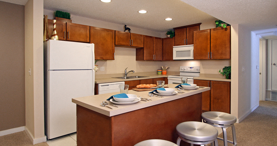 Apartments with upgraded kitchen, chestnut-colored cabinets, kitchen island, breakfast bar, lots of cabinet space, lots of counter space at Alpine Village Apartments in La Vista, Nebraska