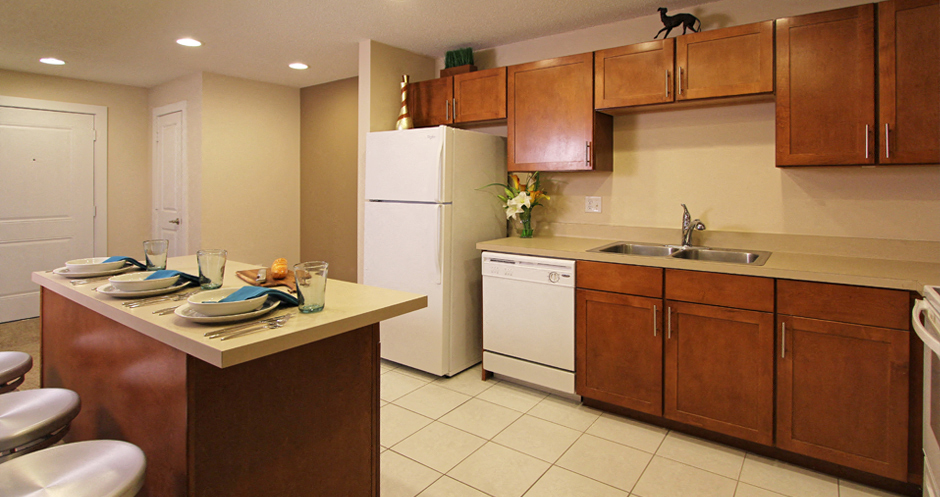 Apartments with upgraded kitchen, chestnut-colored cabinets, kitchen island, breakfast bar, lots of cabinet space, lots of counter space at Alpine Village Apartments in La Vista, Nebraska