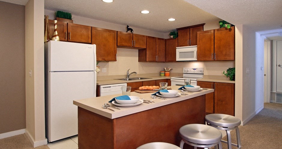 Apartments with upgraded kitchen, chestnut-colored cabinets, kitchen island, breakfast bar, lots of cabinet space, lots of counter space at Alpine Village Apartments in La Vista, Nebraska