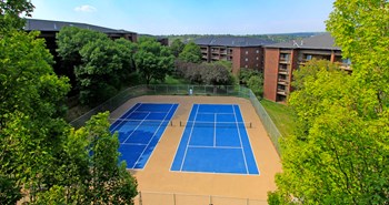 Tennis courts and park-like setting with lots of trees and scenic views at Embassy Park Apartments in Omaha, Nebraska - Photo Gallery 15
