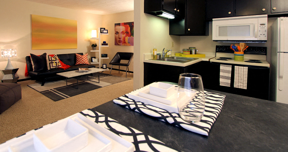 Apartments in central Omaha with spacious layout, spacious living room, and black kitchen cabinets at Kensington Woods Apartments in Omaha, Nebraska