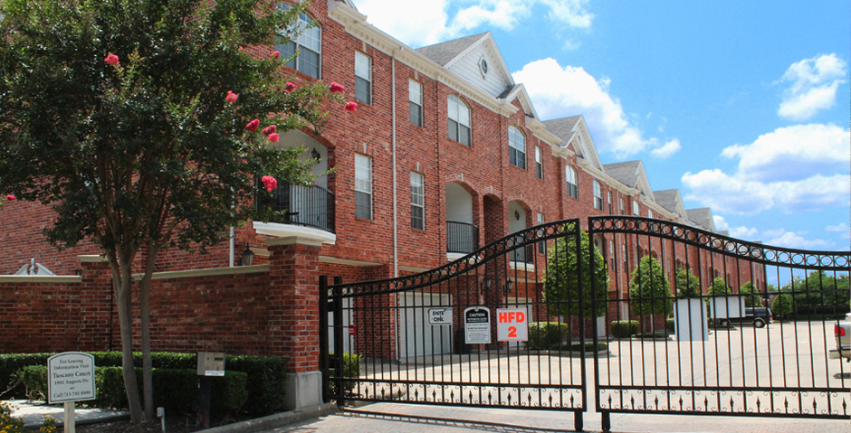 Luxury townhomes in a gated community with red brick exteriors and attached 2-car garages at Tuscany Row Townhomes in Houston.