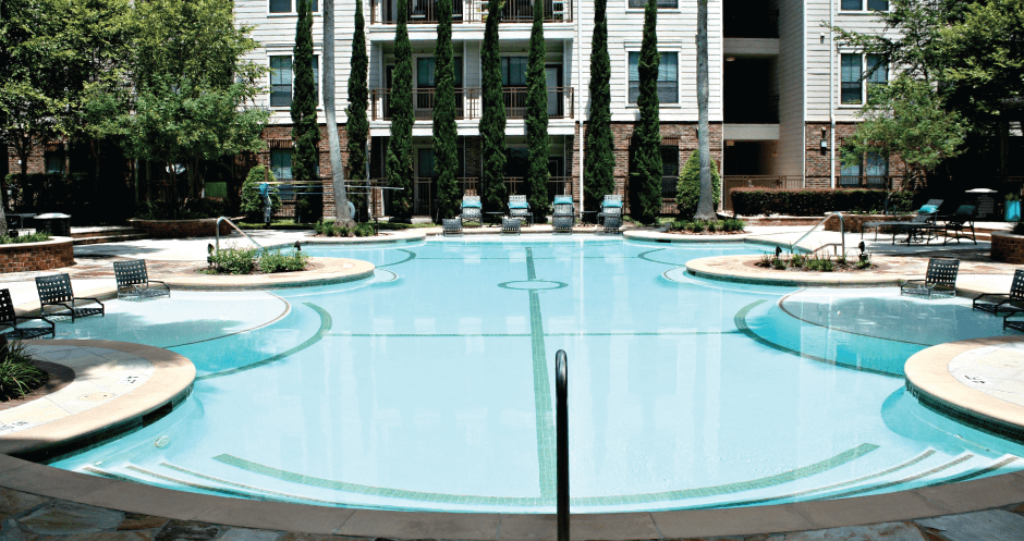 Luxury swimming pool with cabanas, poolside lounges, grilling stations, palm trees and beautiful landscaping at The Voss Apartments in Houston.