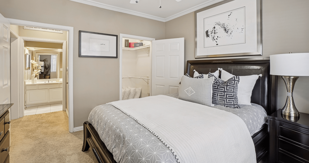 A bedroom with a large bed and a dresser with a mirror.