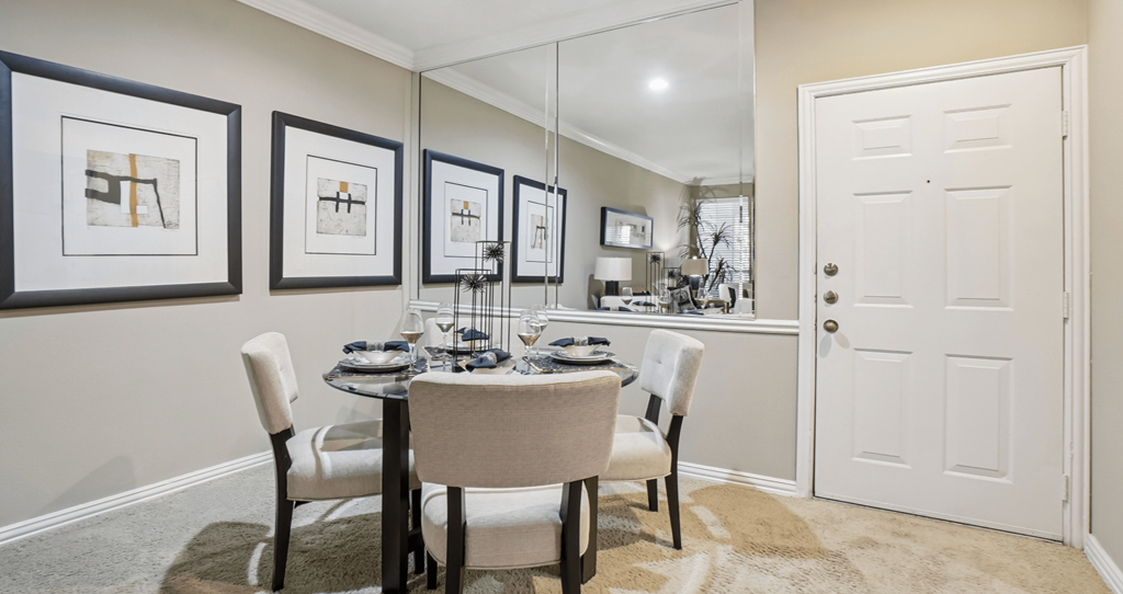 A dining room with a table set for four.