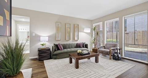 A living room with a couch, a coffee table, and a potted plant.