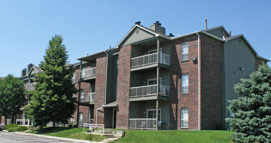 Apartments with brick exteriors, beautiful landscaping, lush landscaping, scenic views, large balconies, spacious balconies, at Alpine Village Apartments in La Vista, Nebraska