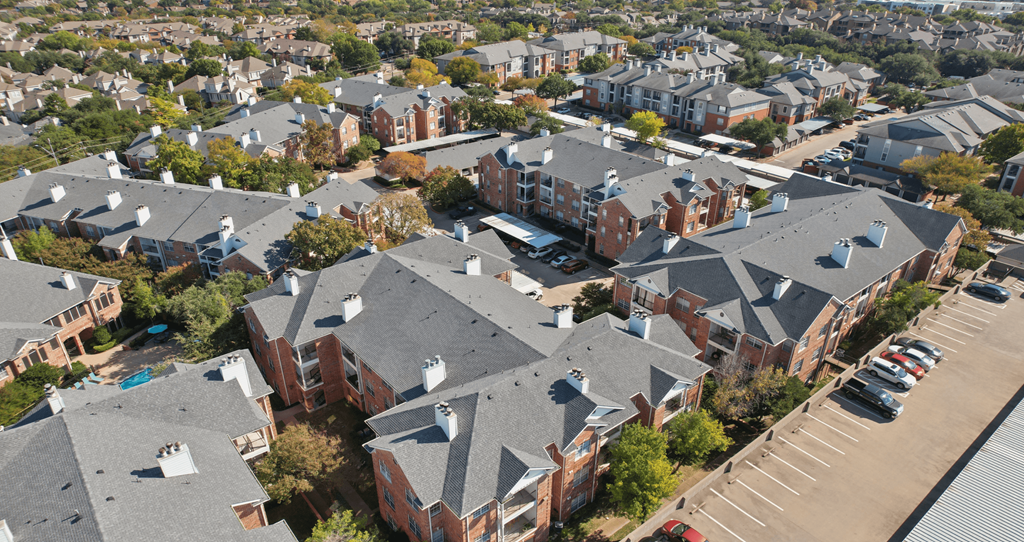 A bird's eye view of a residential area with houses and parked cars.