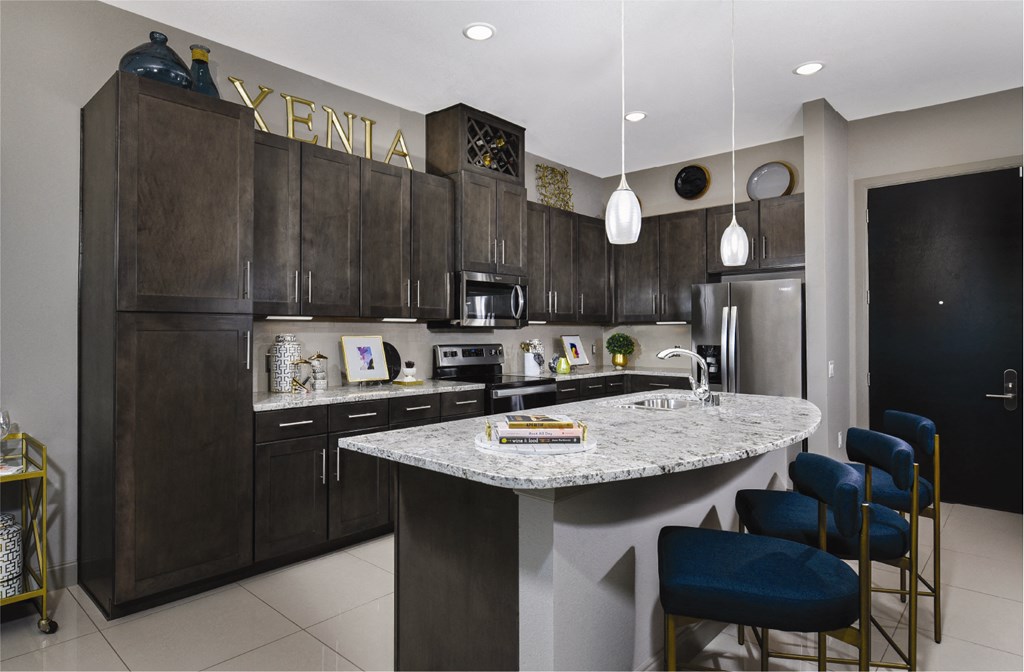 Luxury apartments with granite countertops, stainless steel appliances, built-in wine rack, kitchen island, and porcelain tile floor at Xenia Apartments in Golden Valley, Minnesota