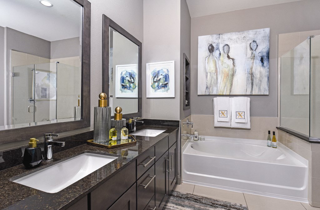 Luxury bathroom with granite countertops, double sink vanity, glass shower and built-in shelves at Xenia Apartments in Golden Valley, Minnesota