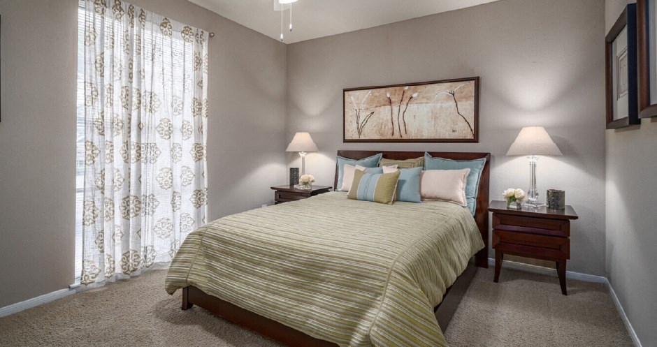 Spacious bedroom with walk-in closet and gray painted walls at Woodlake on the Bayou Apartments