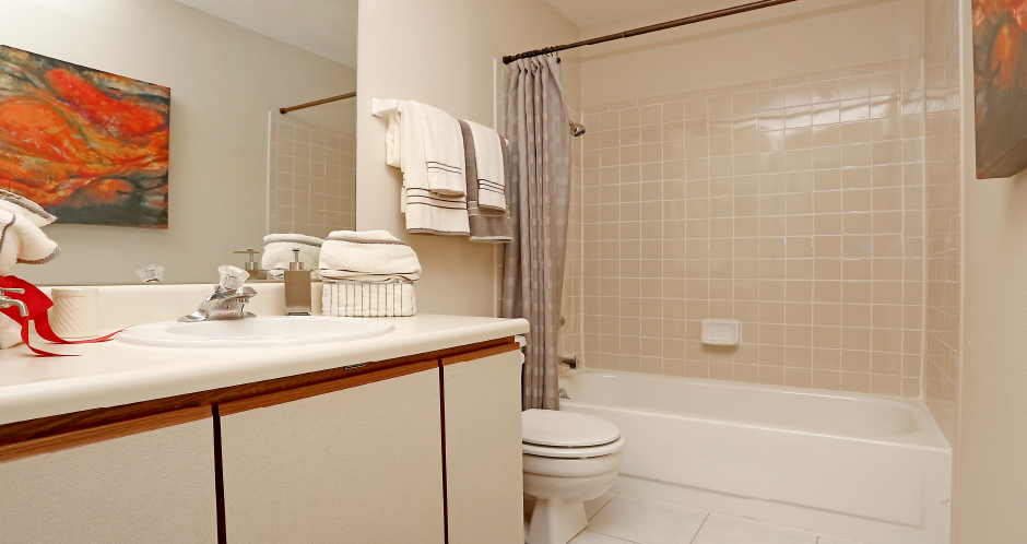 Spacious bathroom with lots of cabinet space, tiled floors and tiled showers with tubs at LionsHead Apartments in Omaha, Nebraska