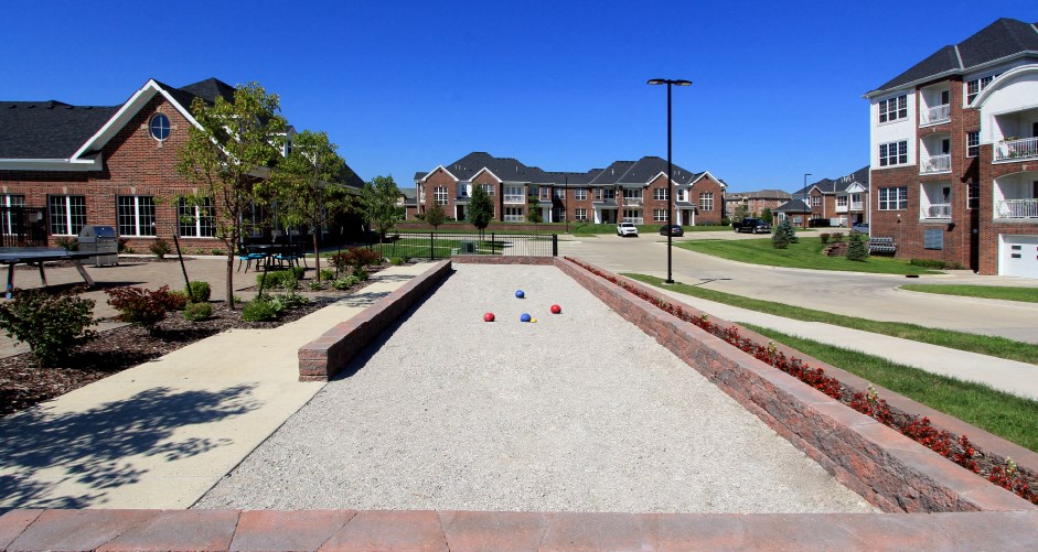 Luxury apartments with swimming pool, poolside lounges, grilling station, ping-pong table, and bocce ball court, and brick exteriors at Bellemeade Apartments in west Des Moines