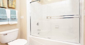 Luxury bathroom with tiled floors, glass shower, and oval soaking tub at Rockledge Oaks Apartments in Lincoln, Nebraska - Photo Gallery 30