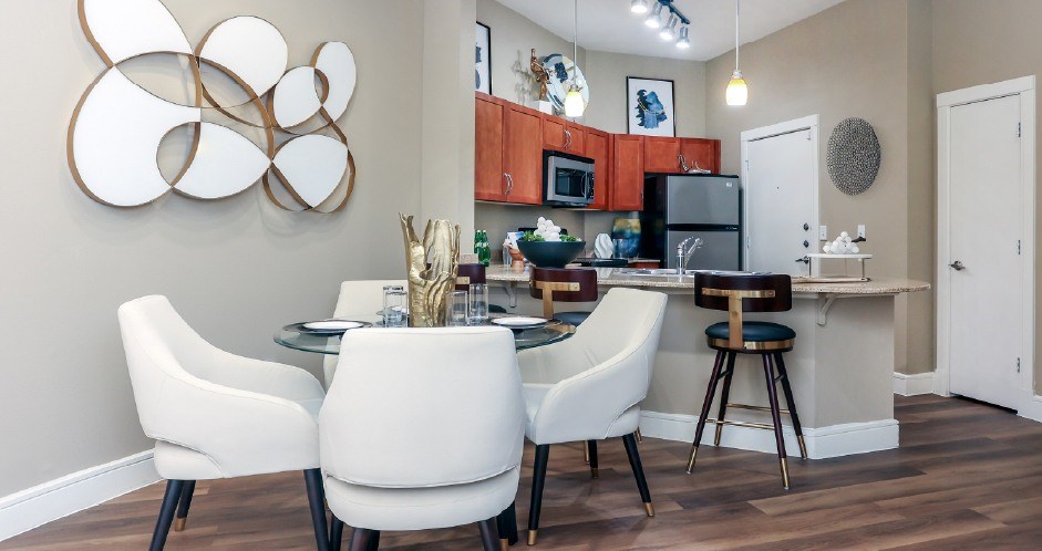 Luxury apartments with granite countertops, stainless appliances, large kitchen island, and dining room area at Delante apartments in Irving Texas