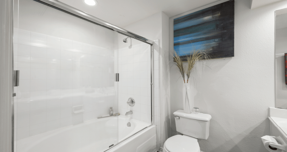 Luxury apartments with oval soaking tub with glass enclosure and glass shower at Tuscany Park Apartments in Houston.
