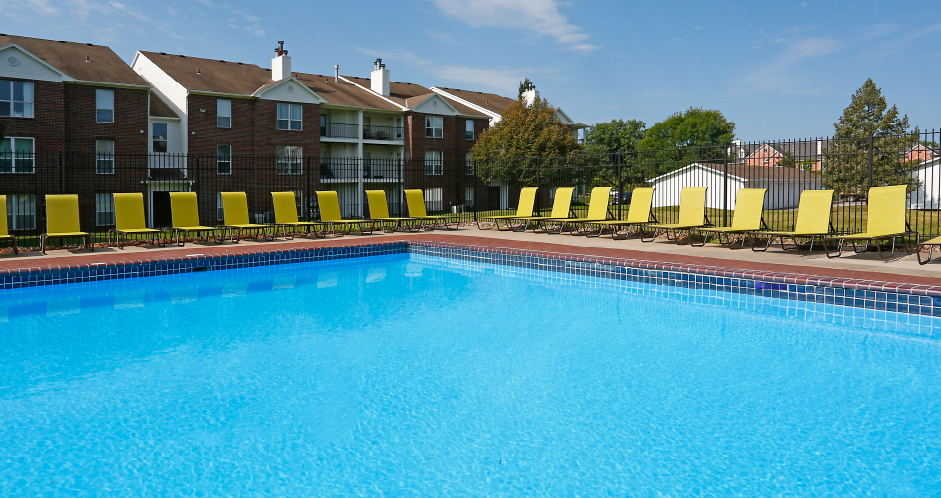 Huge swimming pool with spacious sundeck, poolside lounge chairs, beautiful landscaping, and scenic views at The Vanderbilt Apartments in Omaha, Nebraska