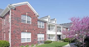 Luxury apartments with red brick exteriors, beautiful landscaping, and scenic views at Rockledge Oaks Apartments in Lincoln, Nebraska - Photo Gallery 6