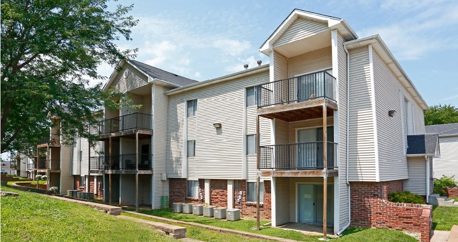 an apartment building with brick and white siding