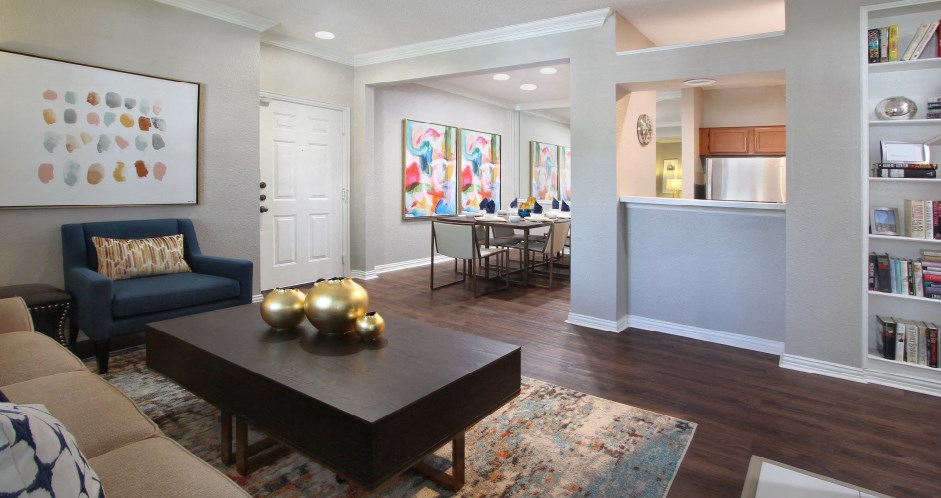 Luxury apartments with wood grain plank floors, built-in shelves, and spacious dining room with mirror accent wall at Lenox Village Apartments in Lincoln, Nebraska