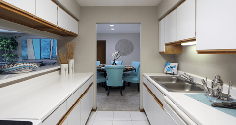 a kitchen with white cabinets and a sink and a dining room