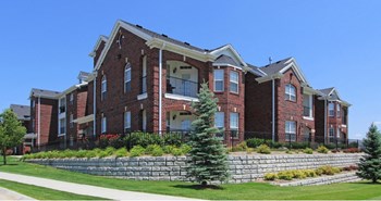 Luxury apartments with spacious balcony, red brick exterior, and beautiful landscaping at Rockledge Oaks Apartments in Lincoln, Nebraska - Photo Gallery 24
