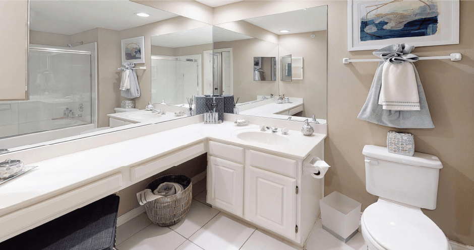 Luxury apartments with spacious bathrooms with tiled floors, linen closet, oval soaking tubs, built-in vanity, cultured marble vanity, glass shower and white cabinets in at The Saxony Apartments