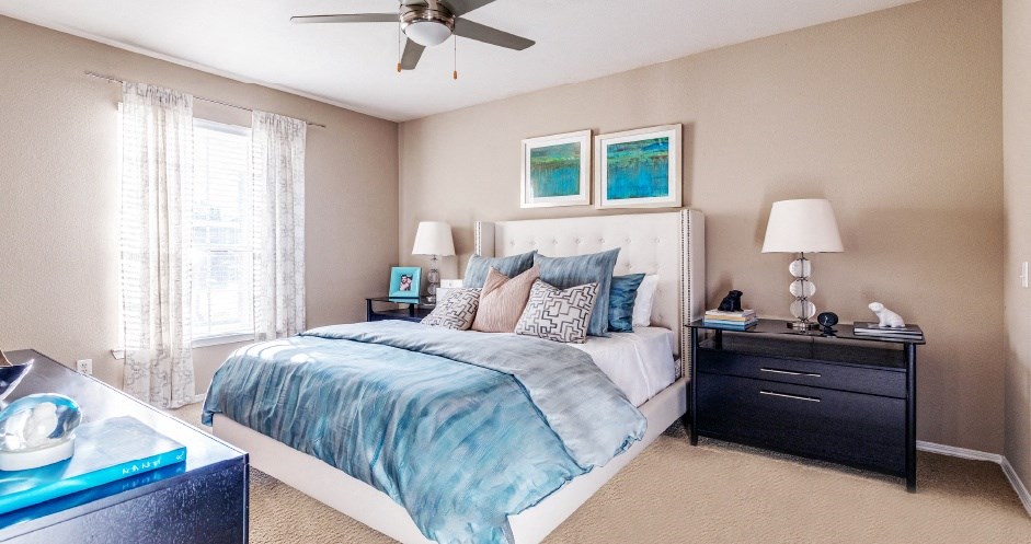 Spacious master bedroom with attached master bathroom, spacious walk-in closet and grey colored walls at Village on the Parkway Apartments in Houston, Texas