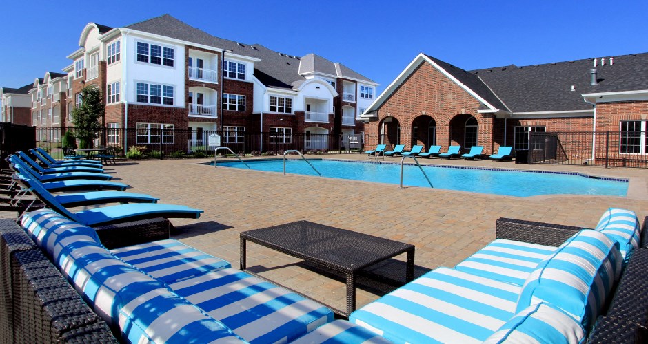 Luxury apartments with swimming pool, poolside lounges, and brick exteriors at Bellemeade Apartments in west Des Moines