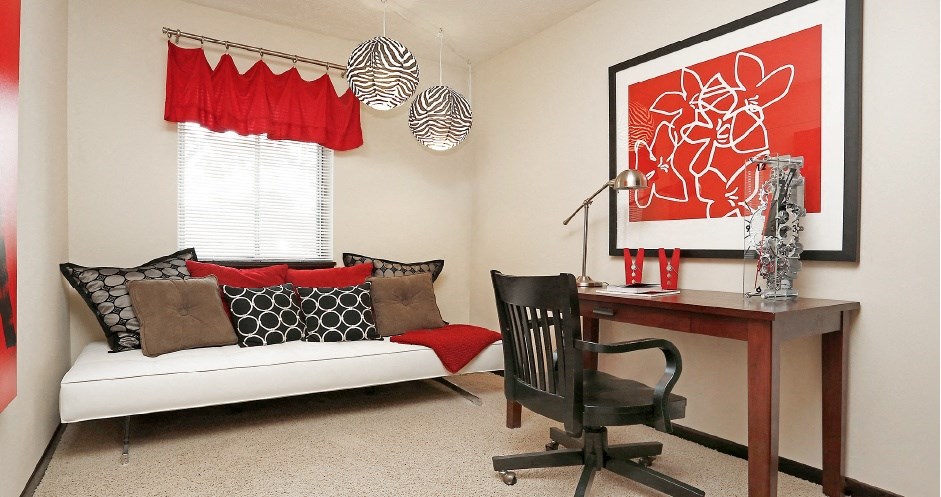 a living room with a desk and a couch