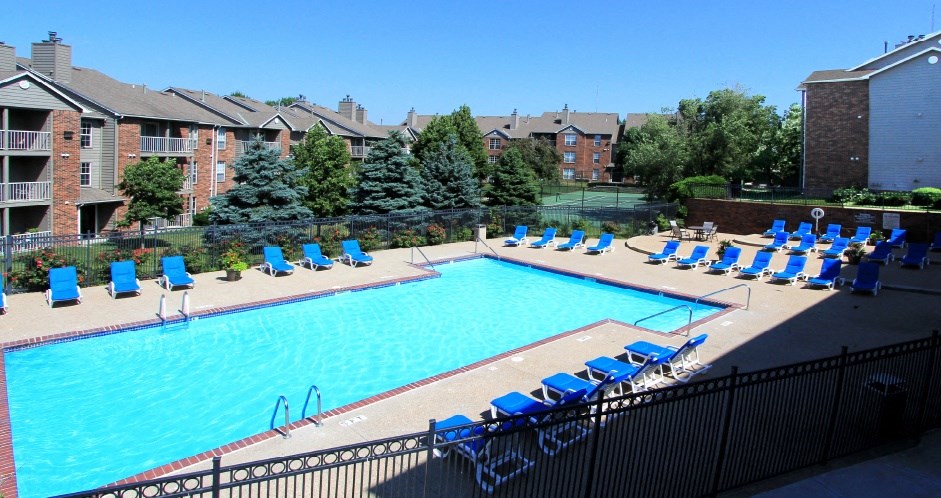 Apartments with large swimming pool, spacious sundeck, lots of poolside lounge chairs, and scenic views at Tanglewood Apartments in Lincoln, Nebraska