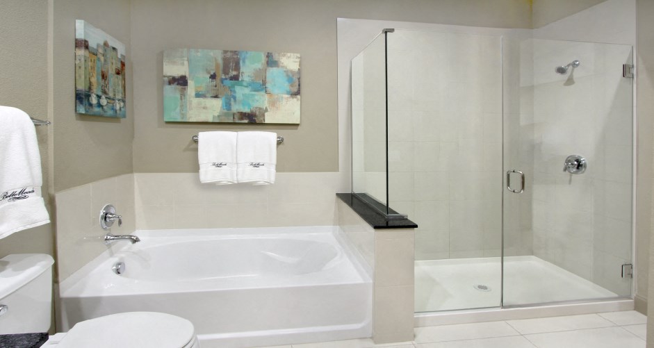Luxury bathroom with oval soaking tub, glass shower, granite countertops and linen closet at Bellemeade Apartments in west Des Moines