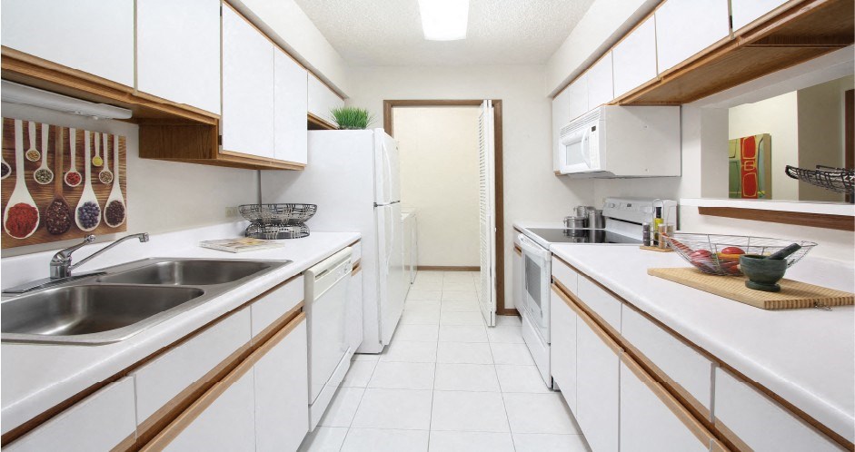 Bright white kitchen with lots of cabinet space, lots of counter space, and full-size washer and dryer in unit at LionsGate Apartments in Lincoln, Nebraska