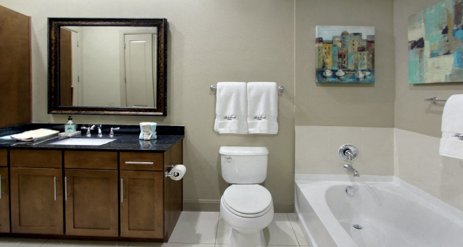 Luxury bathroom with oval soaking tub, glass shower, granite countertops and linen closet at Bellemeade Apartments in west Des Moines