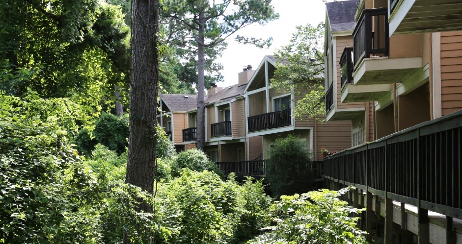 Gated apartments with convenient bayou location, lush landscaping, and scenic views at Woodlake Oaks Apartments in Houston