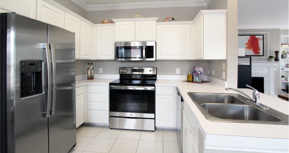 Luxury apartments with spacious u-shaped kitchen, white cabinets, stainless steel appliances, bright white kitchen at Rockledge Oaks Apartments in Lincoln, Nebraska