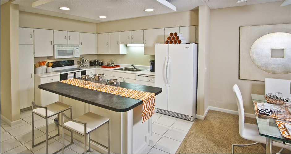 Large kitchen with lots of cabinet and counter space, white cabinets, kitchen island, and prep island at Embassy Park Apartments in Omaha, Nebraska