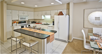 Large kitchen with lots of cabinet and counter space, white cabinets, kitchen island, and prep island at Embassy Park Apartments in Omaha, Nebraska - Photo Gallery 20