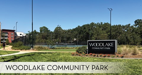 A sign for Woodlake Community Park is displayed in front of a building.