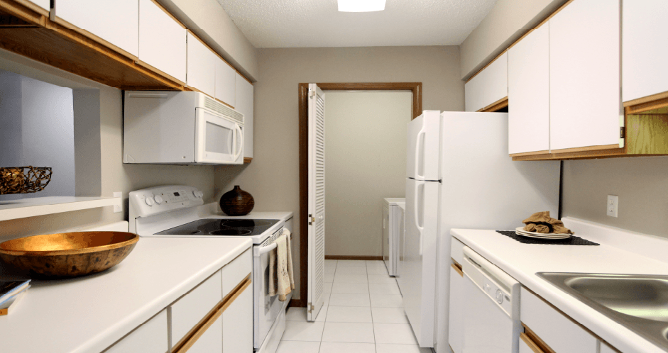 Kitchen with lots of cabinet space, lots of counter space, gray wall color, and full-size washer and dryer at The Vanderbilt Apartments in Omaha, Nebraska