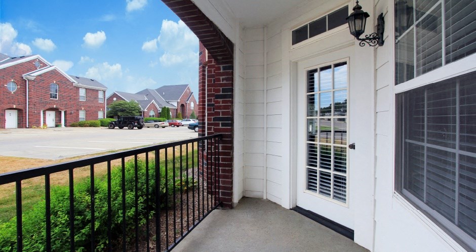 Luxury apartments with spacious balcony, red brick exterior, and beautiful landscaping at Rockledge Oaks Apartments in Lincoln, Nebraska