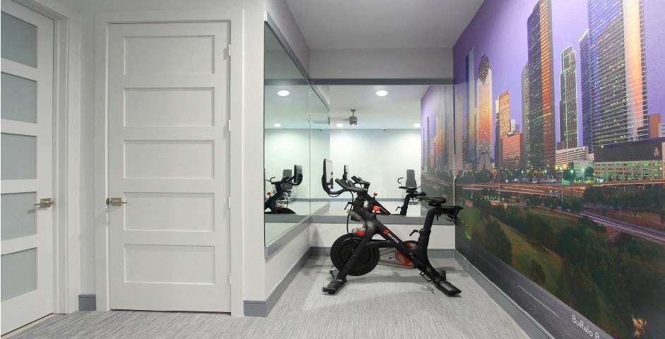 Newly remodeled Fitness Center open 24/7 with brand new Life Fitness equipment including 1 peloton bike, 4 resistance machines, 2 treadmills, 1 life cycle, 1 elliptical, full rack of free weights and dumbbells and water bottle refill fountain at Tuscany Apartments in Houston.